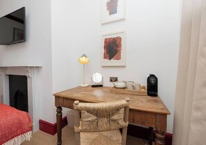 A room with a wooden desk, a chair, a flat-screen TV mounted on the wall, a fireplace, and two framed artworks. - New* Centrally Located room in Bath City Centre - Pass the Keys (Bath)