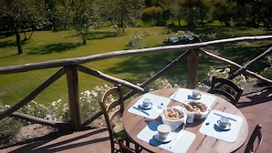 A dining table with chairs and a view of a lake and hills. - Dimora delle Fate – Farm Stay with Experiences, Breakfast Included - Le Ceregne Bio (Pieve Santo Stefano)