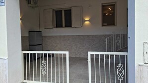 A gated entrance with a tiled floor, a wall-mounted air conditioner, and a window with shutters. - New, detached vacation home near Taranto, ideal for 2-4 people. (Montemesola)