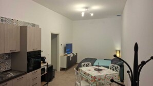 A compact living space with a kitchenette, a dining area, and a seating area. - New, detached vacation home near Taranto, ideal for 2-4 people. (Montemesola)