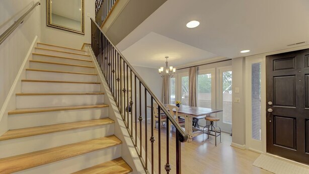A staircase with wooden steps and metal railings leading to a dining area with a table and chairs. - The Landing at Wheat St.| 2Br in the heart of USC (Columbia)
