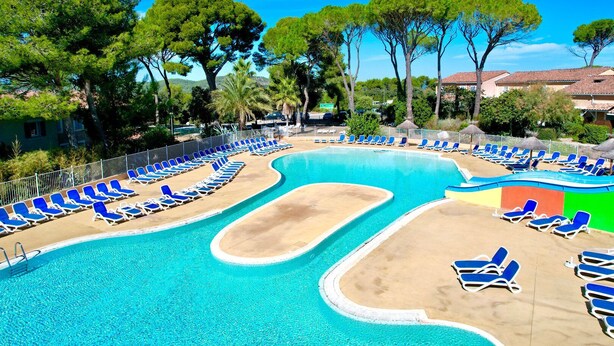A swimming pool with blue lounge chairs and a sandy area, surrounded by trees and buildings. - L’Échappée Belle, 4 guests, Pool in Calvisson (Calvisson)