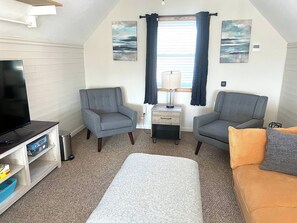 A compact living room with a television, two armchairs, a sofa, a small table, and a lamp. - Cece's Chalet: Hot Tub * New Owner Offer (Mount Jackson)