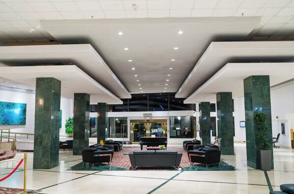 A spacious lobby with a central seating area, large pillars, and a modern ceiling design. - Miami Beach-Front with Amazing Pool (Miami Beach)