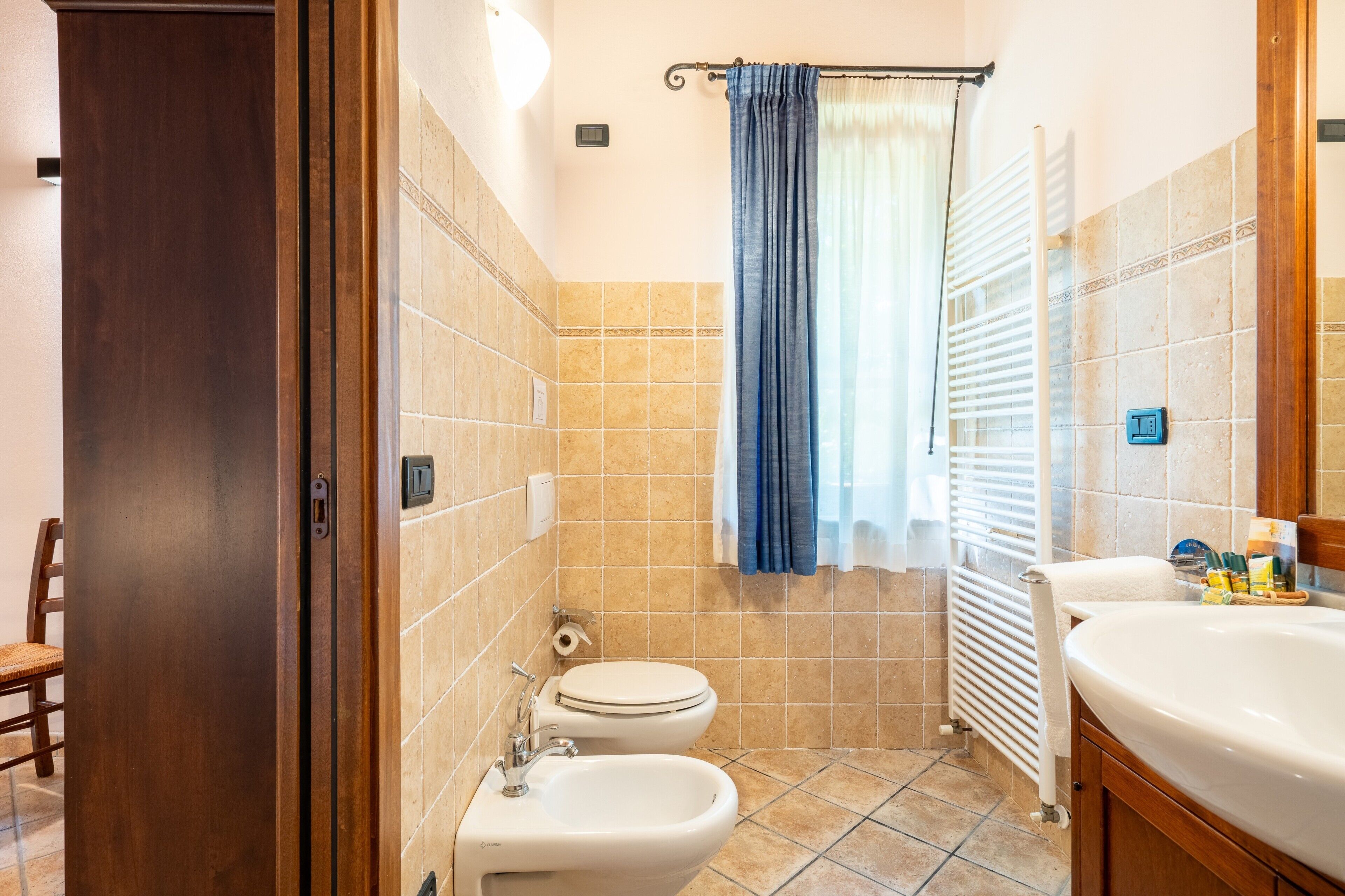 A bathroom with a toilet, bidet, and sink.