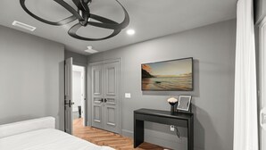 Une chambre à coucher avec un lit, un bureau, un tableau et une porte.