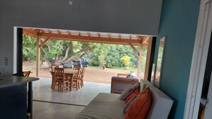 Quarto moderno com cama, escrivaninha e área de refeições.