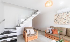 A modern living room with a staircase, a sofa, and a chair. - House 2 Suites in Condo w/ Pool Mnt0058 (Porto Seguro)