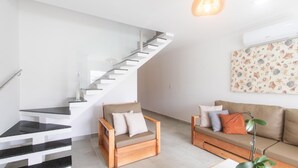 A modern living room with a staircase, a sofa, and a chair. - House 2 Suites in Condo w/ Pool Mnt0058 (Porto Seguro)