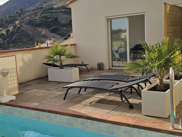 A rooftop terrace with a pool, lounge chairs, and potted plants. - Le Nid de Paulilles in Port-Vendres (Port-Vendres)