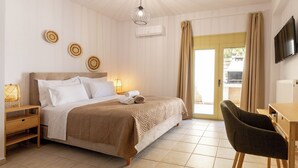 Ein Hotelzimmer mit Bett, Nachttischen, Schreibtisch, Stuhl, Fernseher und einem Fenster mit Vorhängen.