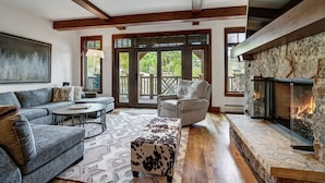 A spacious living room with a fireplace, a sofa, a chair, and a coffee table. - Platinum 3BR Beaver Creek Condo | Ski-in/Ski-out (Avon)