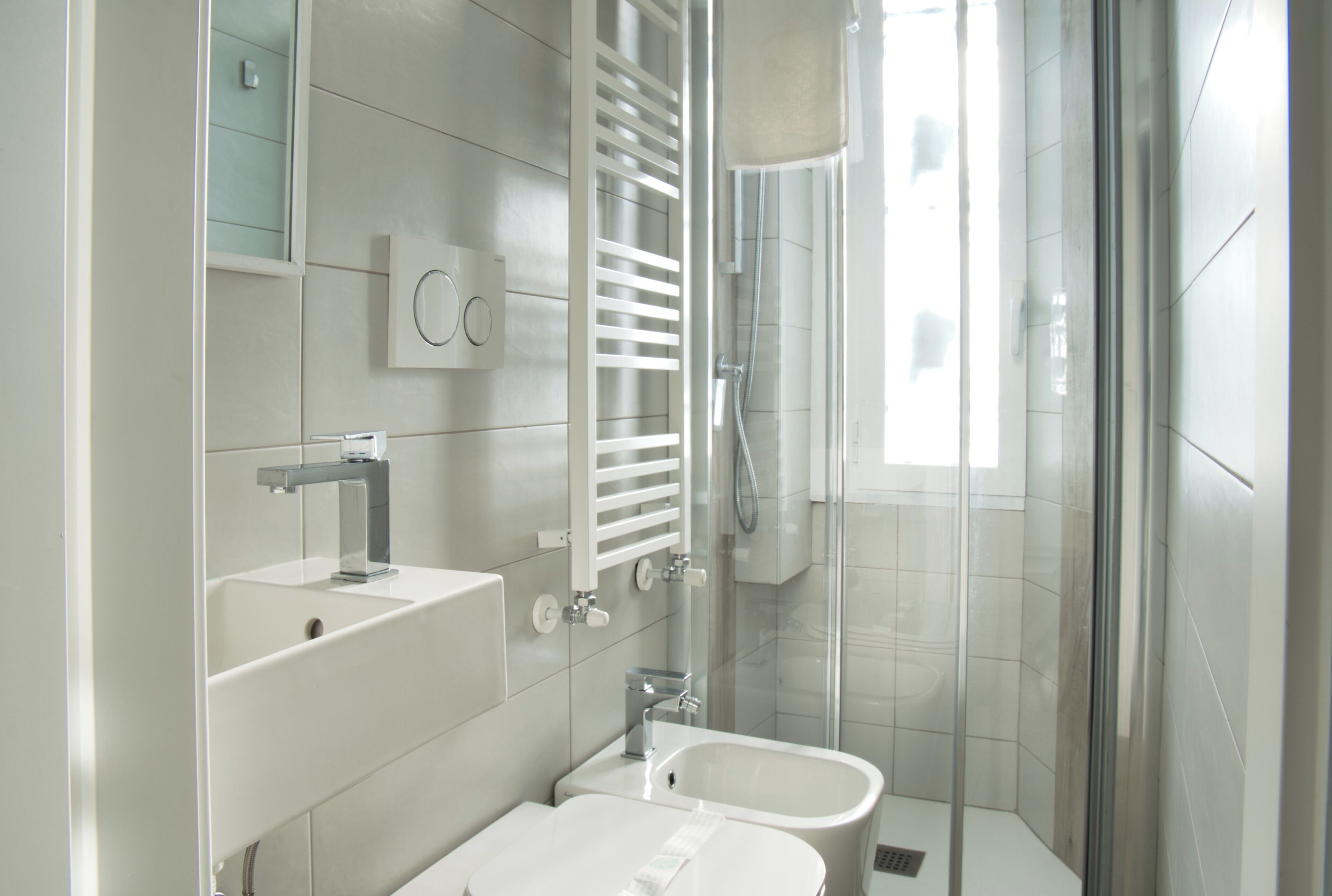 A modern bathroom with a glass shower enclosure, a built-in sink, and a vanity with a mirror.