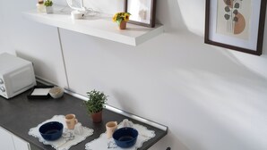 A kitchen with a white countertop, a small potted plant, and a framed picture on the wall. - Cozy Navigli Loft - One Bedroom Apartment, Sleeps 2 (Milano)