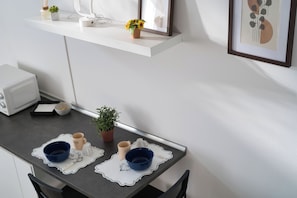 A kitchen with a white countertop, a small potted plant, and a framed picture on the wall. - Cozy Navigli Loft - One Bedroom Apartment, Sleeps 2 (Milano)