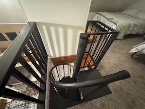 A staircase with a black metal railing and a wooden handrail. - Modern Sunriver Retreat – Sleeps 16 (Sunriver)