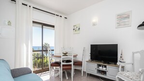 A living room with a TV, a dining table, and a sofa. - Dappan White Apartment, Burgau, Algarve (Burgau)