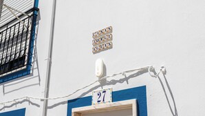 A building facade with a white wall, a blue window frame, and a number plaque indicating 'CASA JORGE AGUAS' and '27'. - Dappan White Apartment, Burgau, Algarve (Burgau)