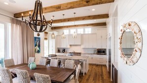 A spacious kitchen with white cabinets, a wooden island, and a large mirror with a seashell border. - Gulf Views | Private Pool | LSV | Elevator (Santa Rosa Beach)