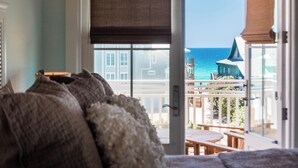 A room with a view of the ocean and a balcony with wooden furniture. - Gulf Views | Private Pool | LSV | Elevator (Santa Rosa Beach)