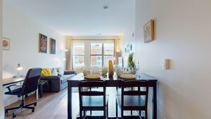 Un comedor con una mesa dispuesta para dos, un sofá y una silla.