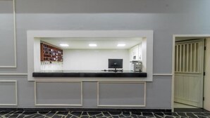 A reception area with a counter, a computer, and a bookshelf. - GoldMen Express Campos dos Goytacazes (Campos)