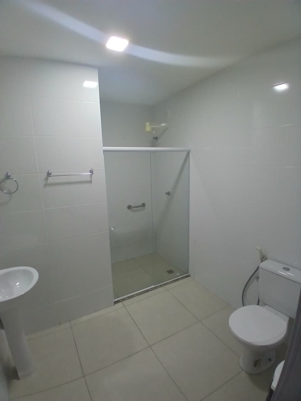 Une salle de bain avec une douche à parois de verre, des toilettes et un lavabo.