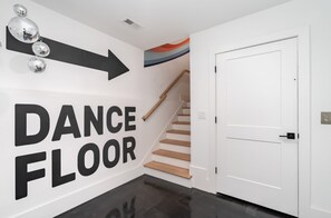 A hallway with a sign indicating the direction to the dance floor. - Fall in Nashville: hot tub, 4BR sleeps 12, garage parking, pet friendly (Nashville)