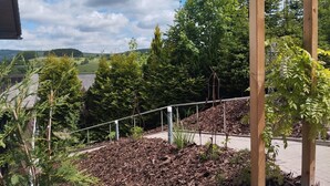 A garden area with a wooden pergola, mulch, and various plants. - DottiesPlace: A cozy vacation rental with sweeping views of the entire area (Winterberg)