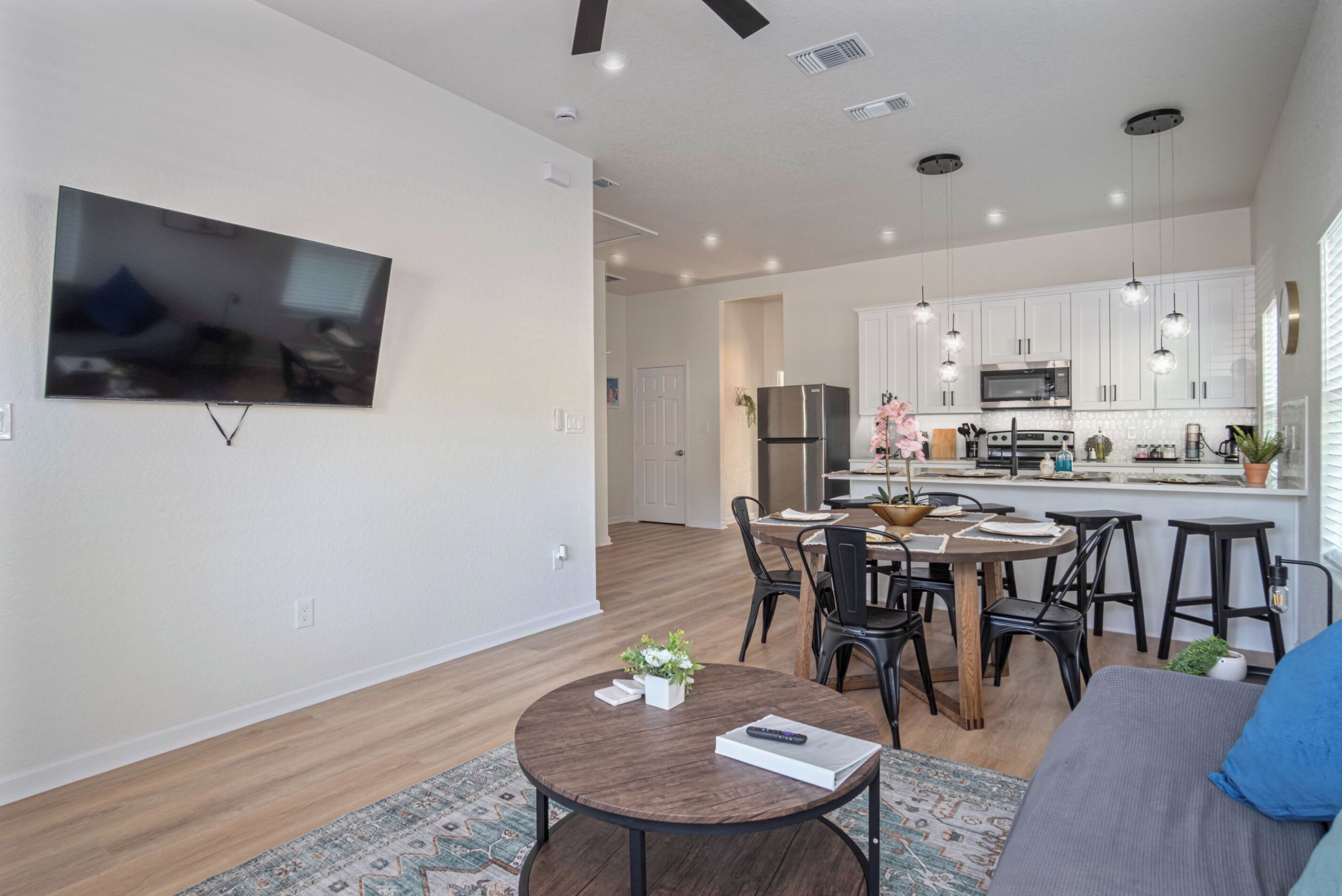 A modern living room with a flat-screen TV, a round coffee table, and a sofa.