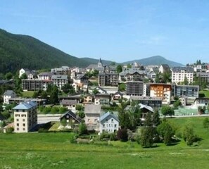 A town with a mix of traditional and modern buildings, surrounded by green hills. - 3rd floor, view mountain, tv, 52m², Villard de Lans (Villard-de-Lans)