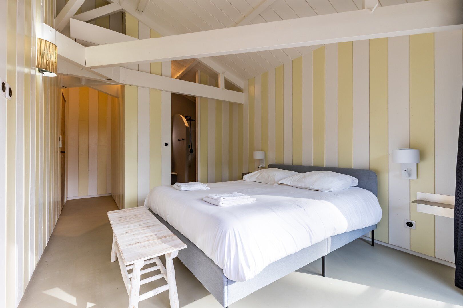 A bedroom with a bed, bedside table, and a walk-in closet.