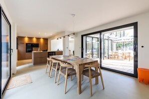 Eine moderne Küche mit Holdekor und ein Essbereich mit einem Holztisch und Stühlen.