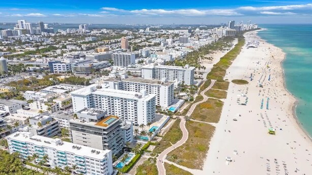 A coastal cityscape with a beachfront hotel featuring multiple buildings, a sandy beach, and a clear view of the ocean. - Oceanfront Studio · South of Fifth + Beach Perks (Miami Beach)