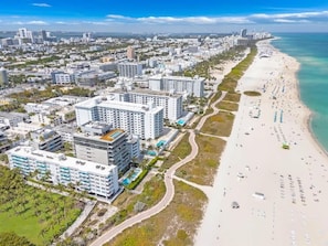 A coastal cityscape with a beachfront hotel featuring multiple buildings, a sandy beach, and a clear view of the ocean. - Oceanfront Studio · South of Fifth + Beach Perks (Miami Beach)