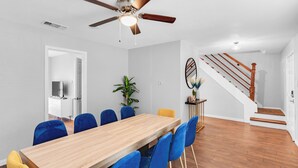 A dining area with a wooden table and blue chairs, a ceiling fan, and a staircase with wooden steps. - 5BR 2.5BA Spacious house sleeps 16 (Flower Mound)