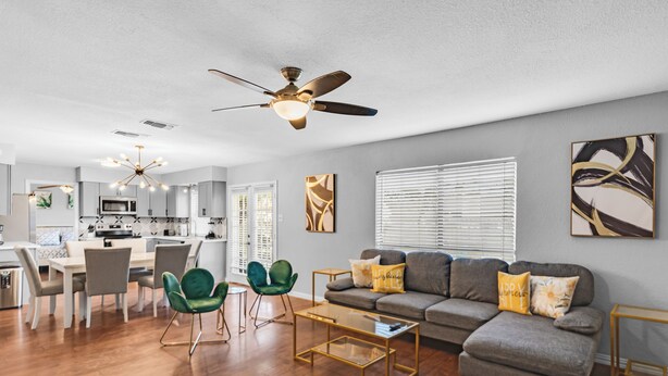 A modern living room with a grey sofa, green chairs, and a coffee table. - 5BR 2.5BA Spacious house sleeps 16 (Flower Mound)