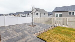Zona residencial con casas, cerca blanca y camino de entrada pavimentado.