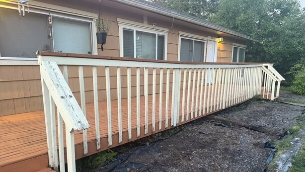 Ein Haus mit einer Holzterrasse und einem überdachten Veranda.