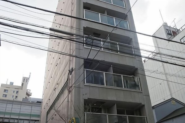 Un immeuble à plusieurs étages, doté de balcons apparents et d’une série de fenêtres.