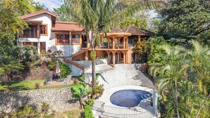 A large house with a swimming pool, surrounded by lush greenery and palm trees. -  Casa Nubes (Puerto Carrillo)