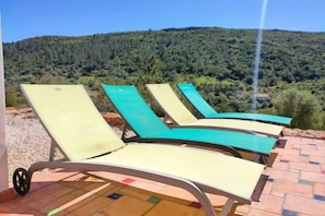 Outdoor lounge chairs with a view of a forested hill. - Casa Bananeira (Sao Bartolomeu de Messines)