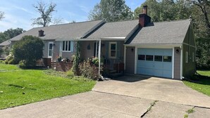 A single-story house with a garage, a front porch, and a well-maintained lawn.