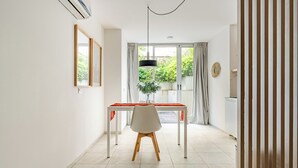 A modern dining area with a white table, a white chair, and a hanging pendant light.