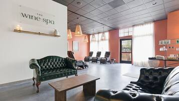 A spacious lounge area with a green sofa, a black leather couch, and a wooden coffee table.