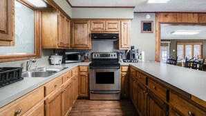 A kitchen with wooden cabinets, stainless steel appliances, and a large island.