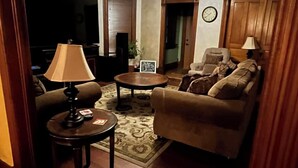 Una sala de estar con ventilador de techo, un sofá, una mesa de centro y una lámpara.
