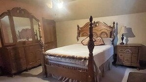 Un dormitorio con cama con dosel, ventilador de techo, cómoda y espejo.