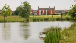 A house with a red brick exterior, a white door, and a chimney. - Ticklepenny (Louth)