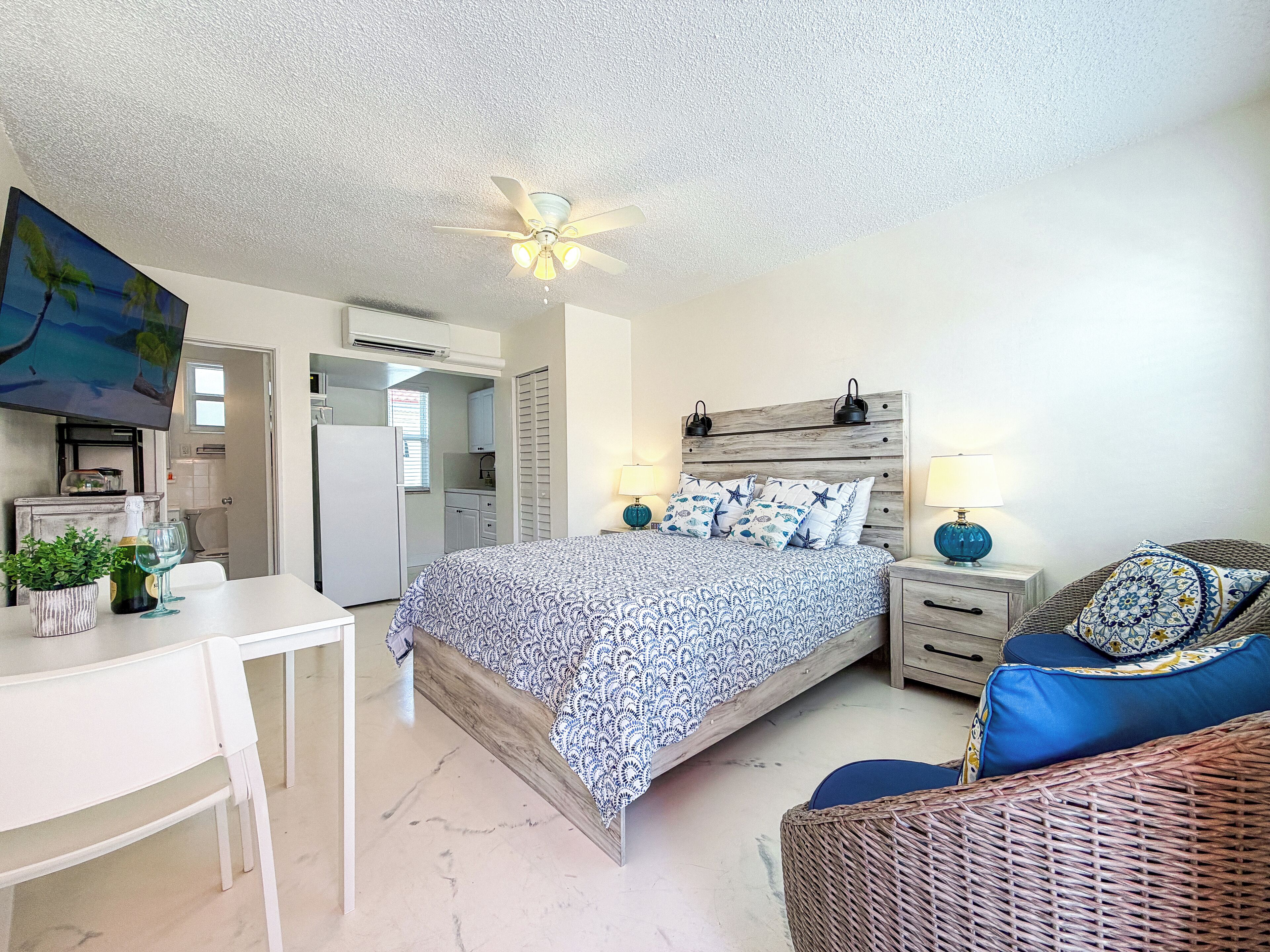 Une chambre à coucher avec un lit, des tables de chevet, un bureau et une chaise.